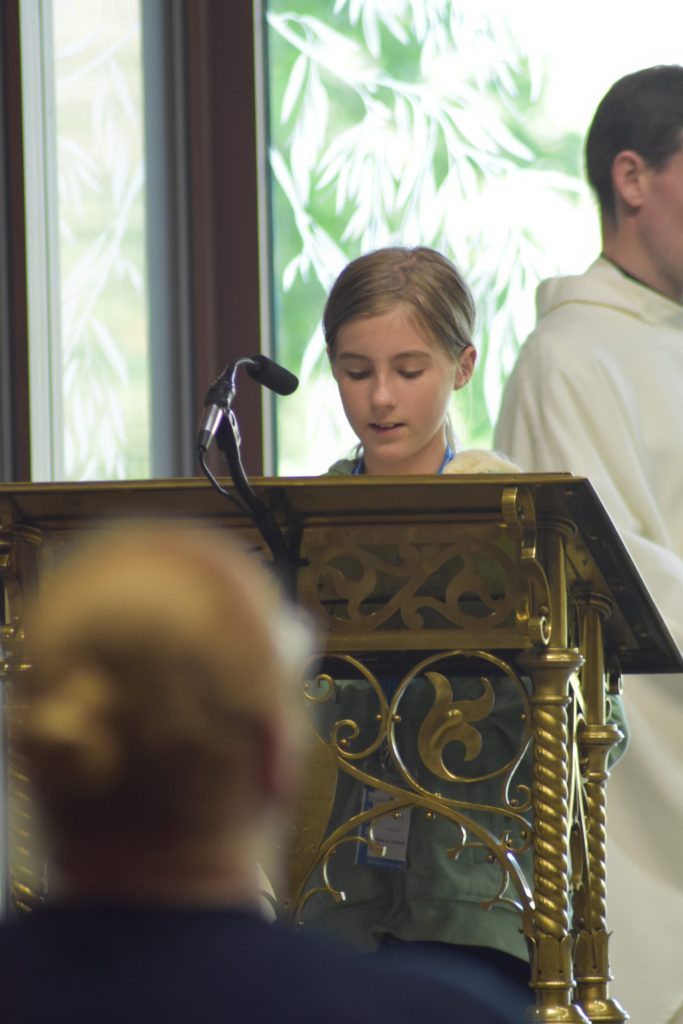 A young person stands at the lectern to read