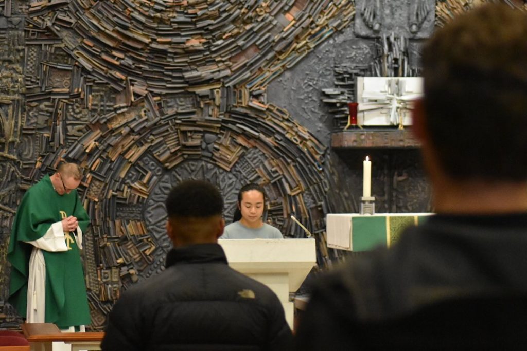 A young woman stands at the lectern to read