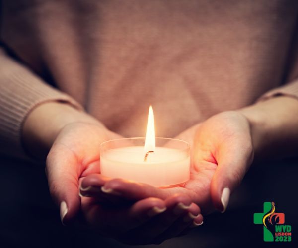 Photo of woman holding a lit candle in her hands