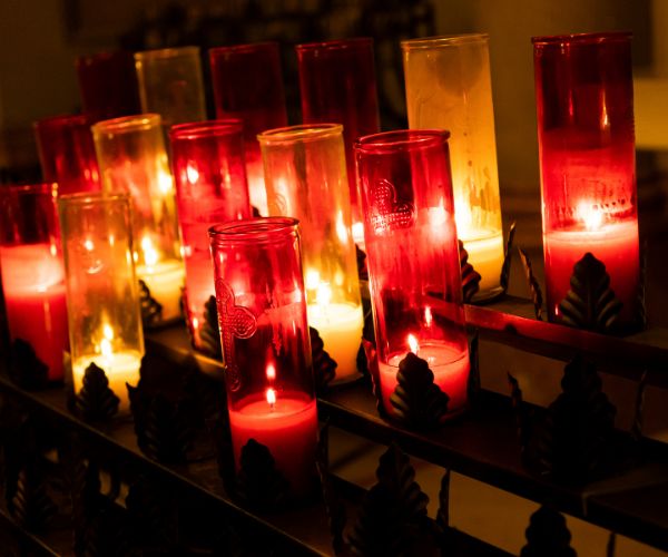 Red and white pillar candles are lit against a dark background