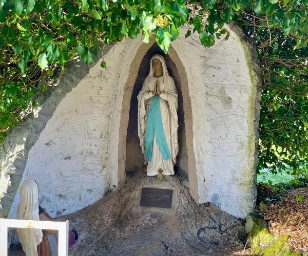 A statue of Our Lady of Lourdes in a grotto in the grounds of the church
