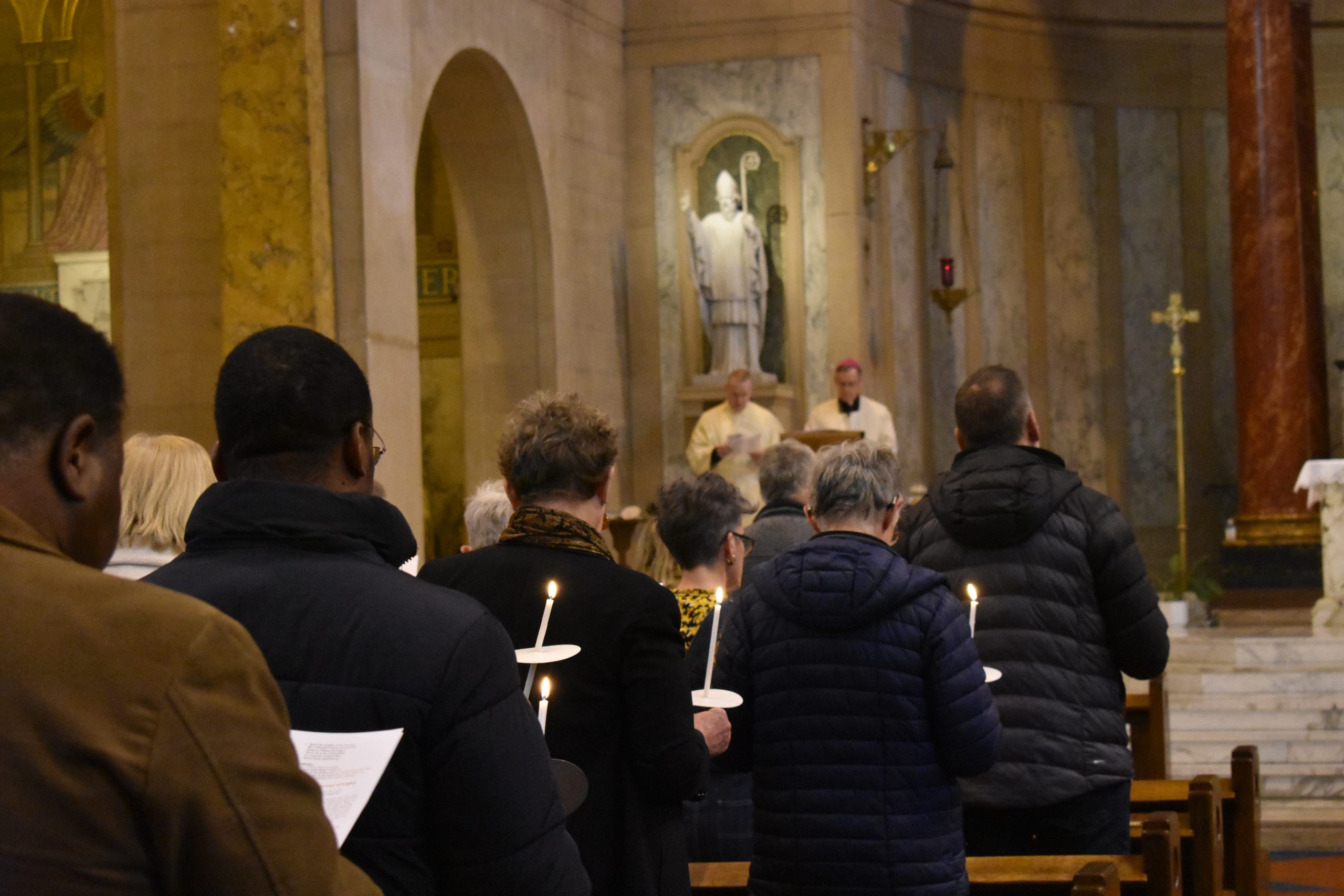 Congregation stand with lit candles to mark the end of our diocesan synod