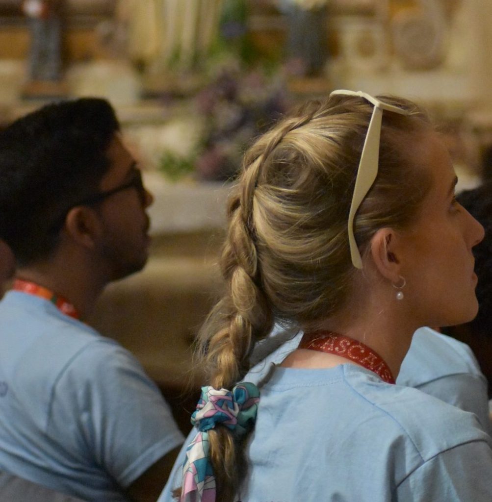 Two young adults pray during Mass